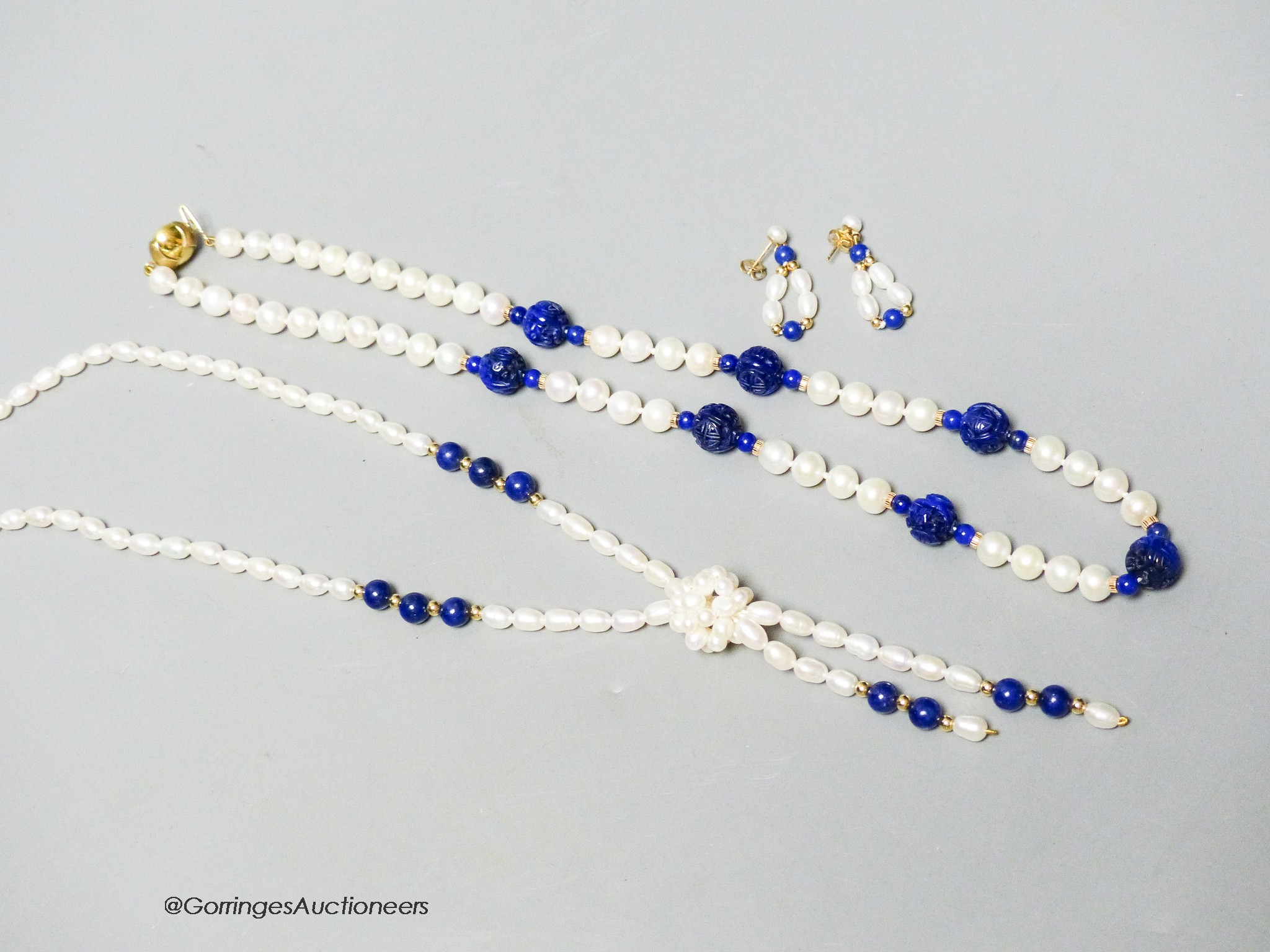 A modern freshwater pearl and lapis lazuli drop necklace with 14k clasp, 64cm, a pair of matching earrings and a similar necklace with 9ct clasp.